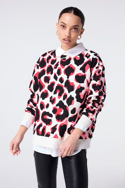  Scamp and Dude Cream with Neon Pink and Black Mega Shadow Leopard Oversized Sweatshirt | Model wearing cream jumper with neon pink and black mega shadow leopard oversized sweatshirt layered over a white collared shirt.