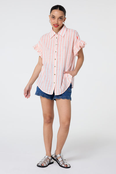 Scamp and Dude Coral and White Stripe Frill Sleeve Shirt | Model wearing coral and white stripe shirt featuring frill sleeves and paired with scallop hem denim shorts.