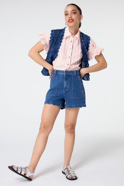 Scamp and Dude Authentic Indigo Scallop Denim Shorts | Model wearing authentic indigo denim shorts with scallop detailing, paired with a coral stripe shirt and scallop waistcoat.