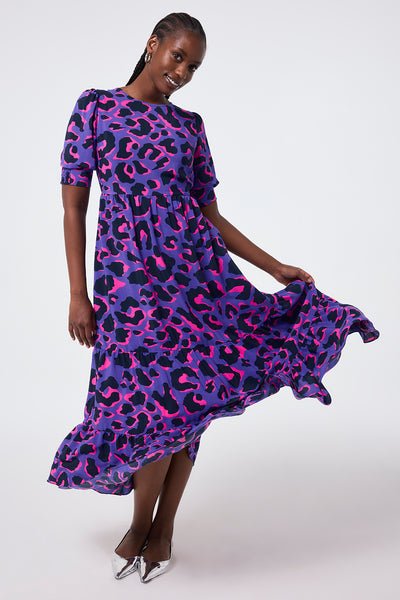Scamp and Dude Purple with Pink and Black Snow Leopard Maxi Dress | Model wearing round neck purple maxi dress with a pink and black snow leopard print. 