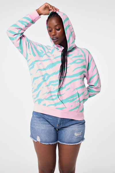 Scamp and Dude Pink with Green Tiger Print Relaxed Hoodie | Model wearing pink hoodie with green tiger print paired with denim shorts.