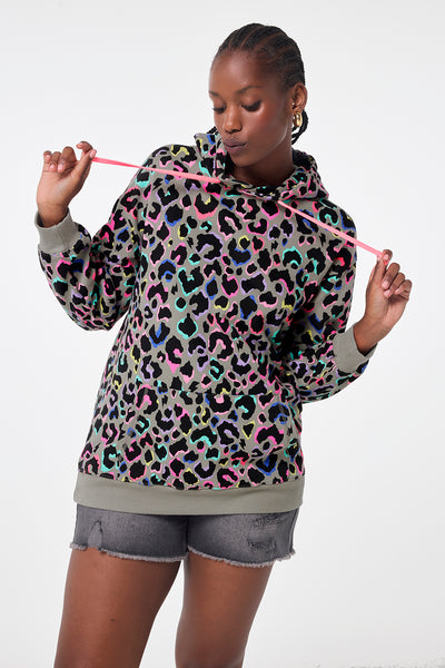 Scamp and Dude Khaki with Rainbow Shadow Leopard Longline Hoodie | Model wearing khaki longline hoodie featuring rainbow shadow leopard print paired with denim shorts.