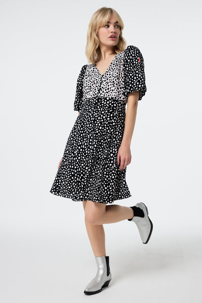 Scamp and Dude White with Black Mix Cheetah Puff Sleeve Short Tea Dress | Model wearing a white with black mix cheetah print short tea dress with puff sleeves and a v-neck.