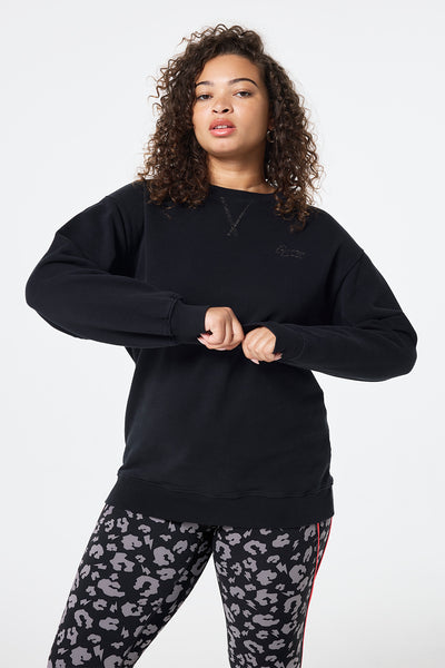 Scamp and Dude Black Longline Sweatshirt | Model wearing black longline crew neck sweatshirt with black and grey leopard print leggings.