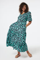 Scamp and Dude Green with Purple and Black Shadow Leopard Tie Front Maxi Dress | Model wearing a short sleeve tie front maxi dress in green with purple and black shadow leopard print.