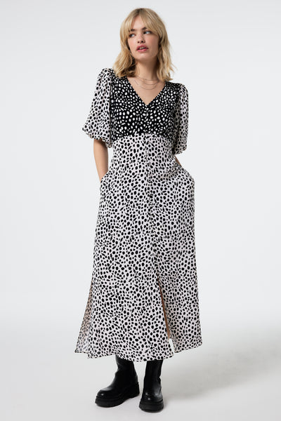 Scamp and Dude White with Black Mix Cheetah Puff Sleeve Midi Tea Dress | Model wearing a white with black mix midi tea dress in a cheetah print featuring puff sleeves.