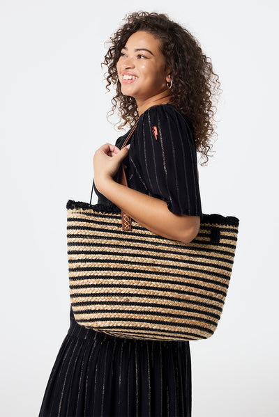 Scamp and Dude Natural with Black Stripe Straw Basket Bag | Model wearing a black tie front maxi dress with a natural with black stripe straw basket bag.