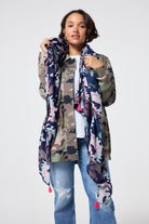 Scamp and Dude Navy with Pink Camo Charity Super Scarf | Model wearing navy and pink camo print scarf with a camo utility jacket and blue jeans.