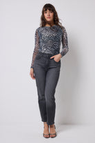 Scamp & Dude Grey Cheetah Mesh Top | Model wearing a cheetah print mesh top and washed black jeans with leopard print high heels.