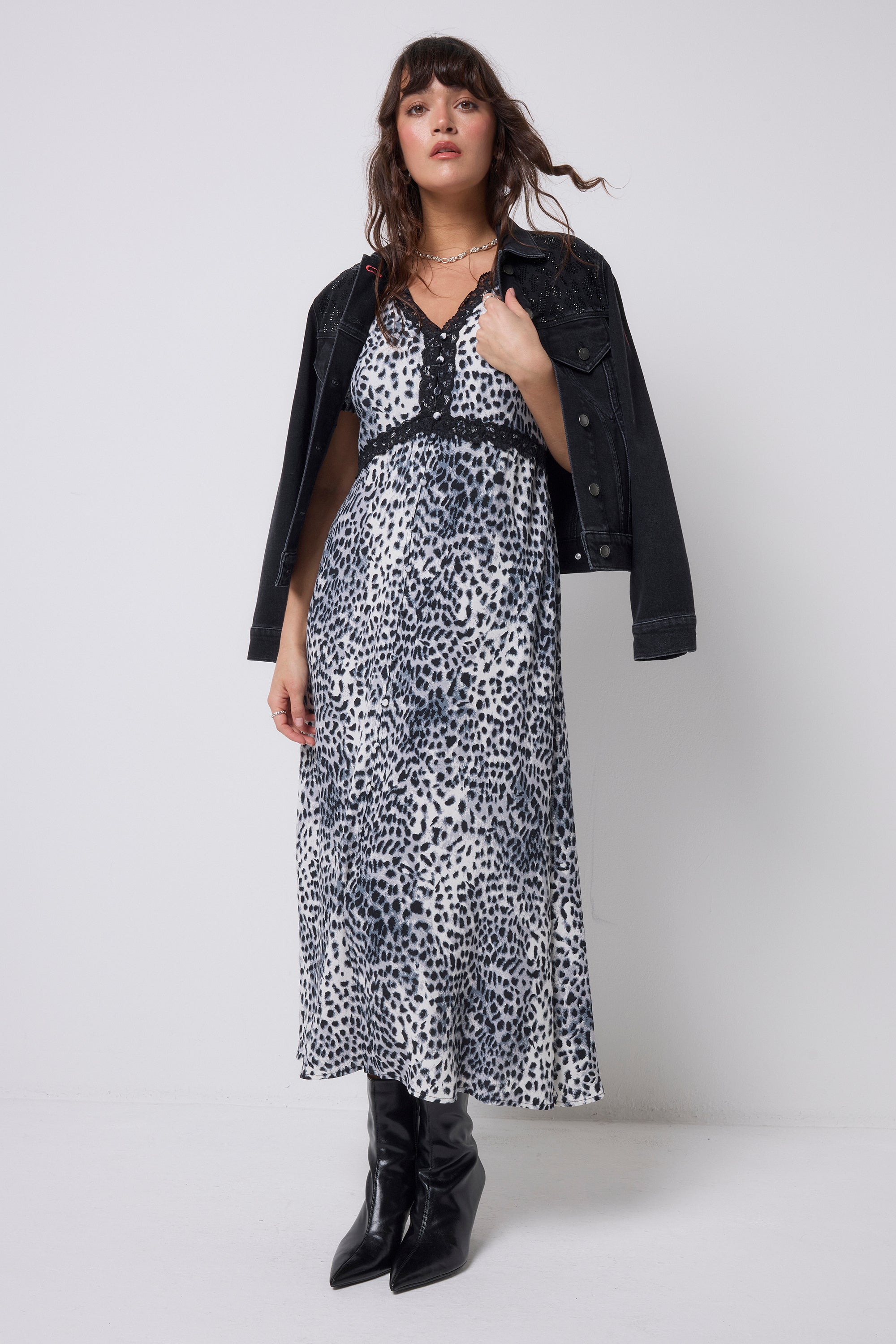 Scamp & Dude Grey Cheetah Lace Trim Puff Sleeve Midi Tea Dress | Model wearing a cheetah print dress with a black jacket and boots on a white background.