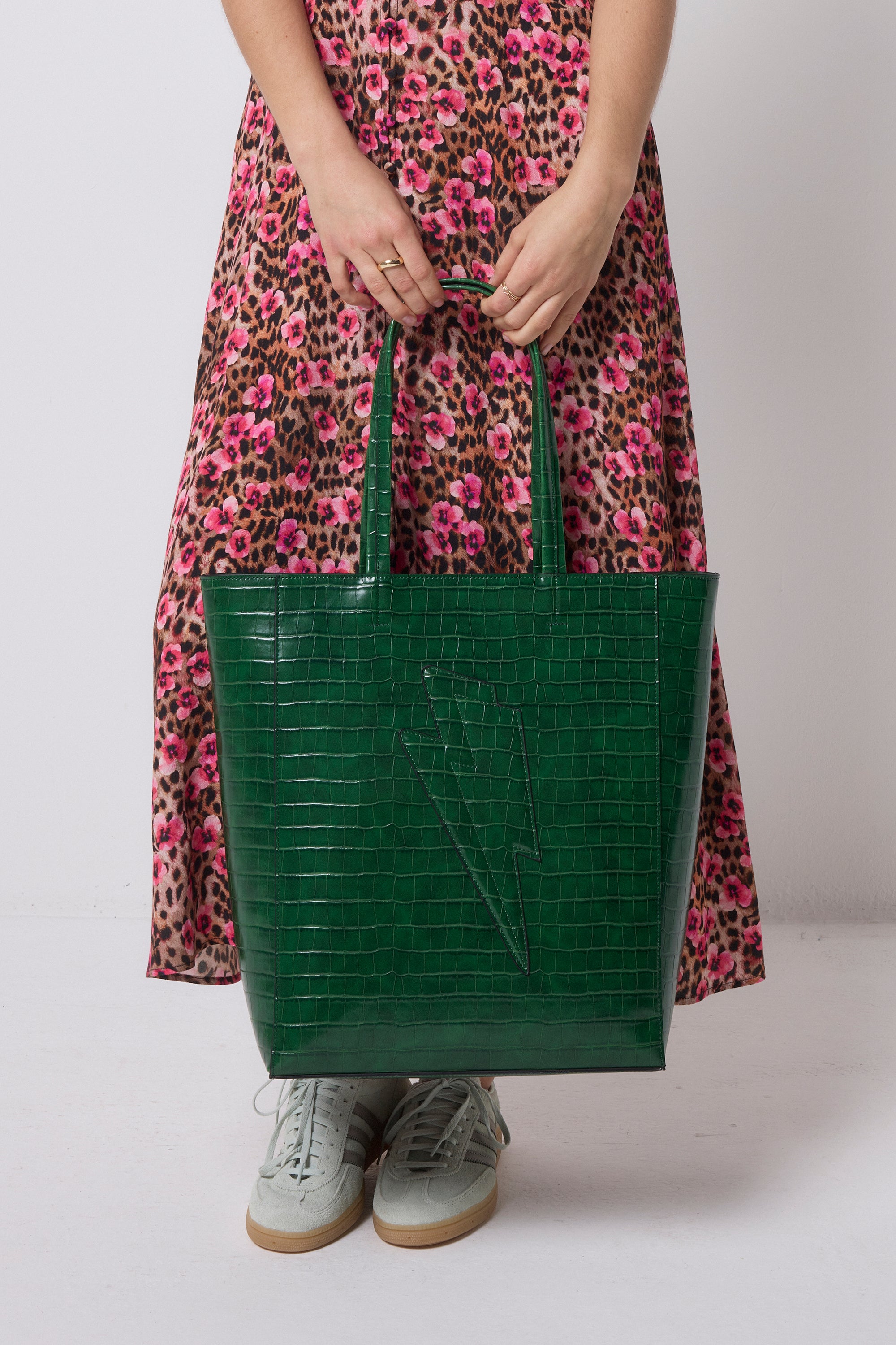 Scamp and Dude Green Lightning Bolt Embossed Croc Tote Bag | Model wearing a neutral floral cheetah print dress, holding a green faux croc tote bag with lightning bolt design.