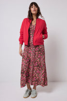 Scamp and Dude Red Lightning Bolt Fitted Quilted Bomber Jacket | Model wearing a red bomber jacket with a neutral paradise cheetah print dress.