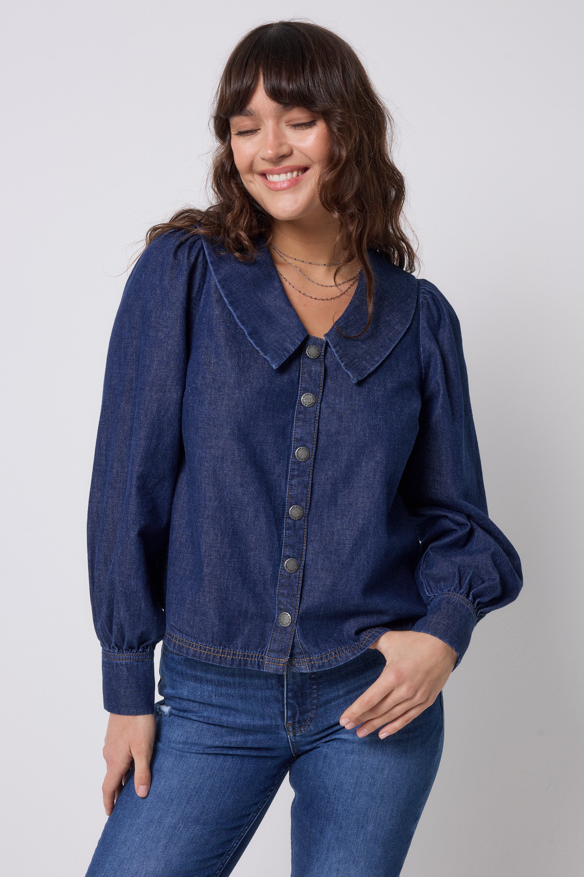 Scamp & Dude Indigo Denim Collared Blouse | Model wearing a blue denim button front blouse with dark blue jeans.