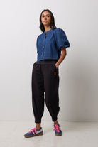 Scamp & Dude Indigo Boxy Puff Sleeve Denim Jacket | Model wearing a cropped blue denim jacket with puff sleeves and black jogger pants.