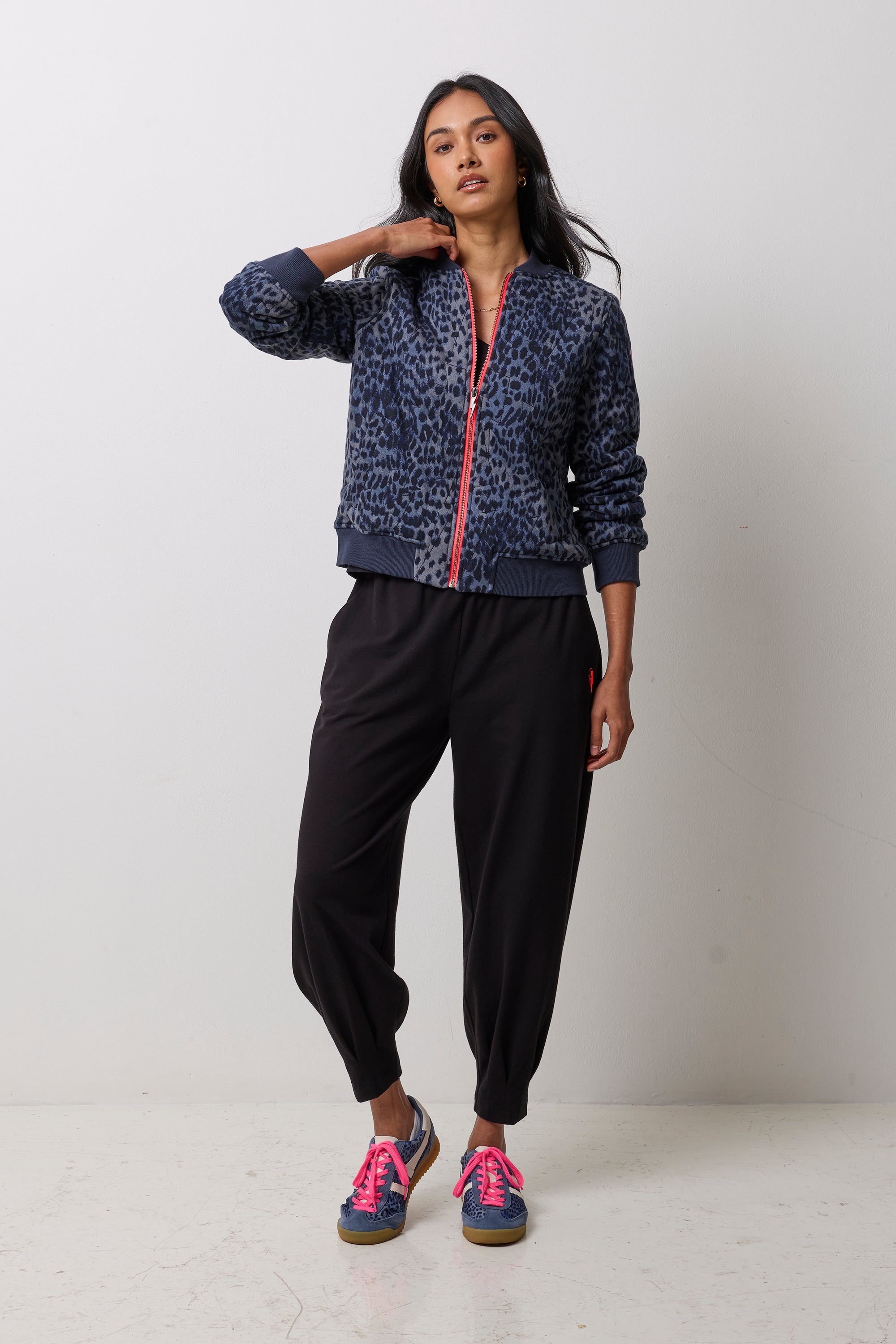 Scamp & Dude Navy Cheetah Fitted Bomber Jacket | Model wearing a pair of black barrel leg joggers with a black t-shirt and navy cheetah print bomber jacket.