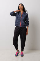 Scamp & Dude Navy Cheetah Fitted Bomber Jacket | Model wearing a pair of black barrel leg joggers with a black t-shirt and navy cheetah print bomber jacket.
