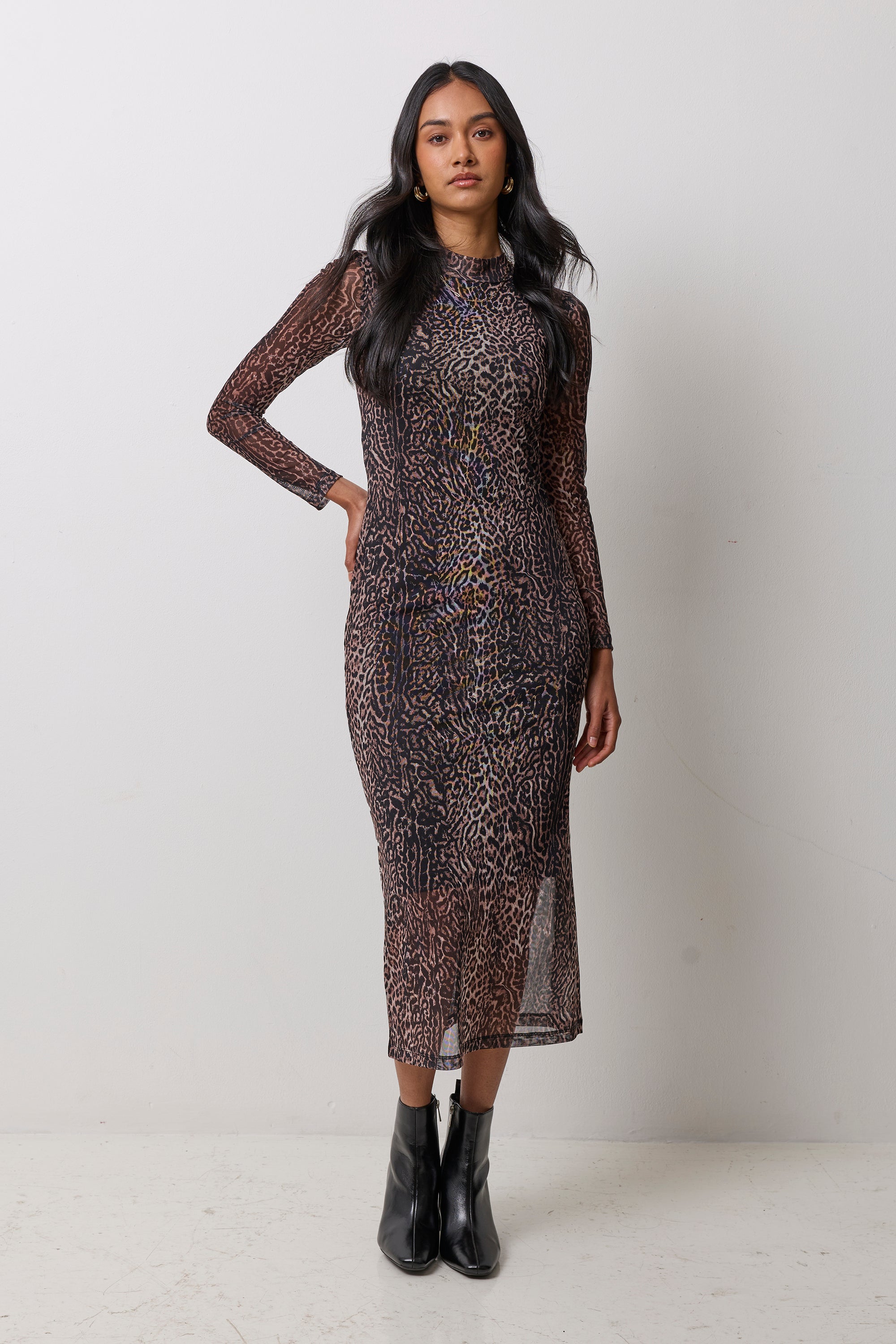 Scamp & Dude Neutral Milano Leopard Mesh Midi Dress | Model wearing a neutral animal print mesh midi dress with black heeled boots and gold jewellery.