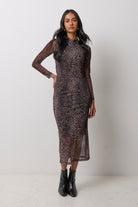 Scamp & Dude Neutral Milano Leopard Mesh Midi Dress | Model wearing a neutral animal print mesh midi dress with black heeled boots and gold jewellery.
