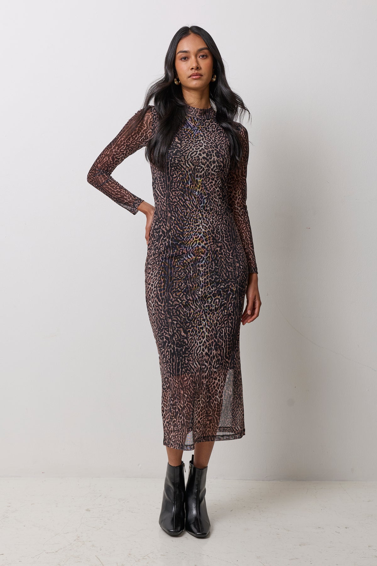 Scamp & Dude Neutral Milano Leopard Mesh Midi Dress | Model wearing a neutral animal print mesh midi dress with black heeled boots and gold jewellery.
