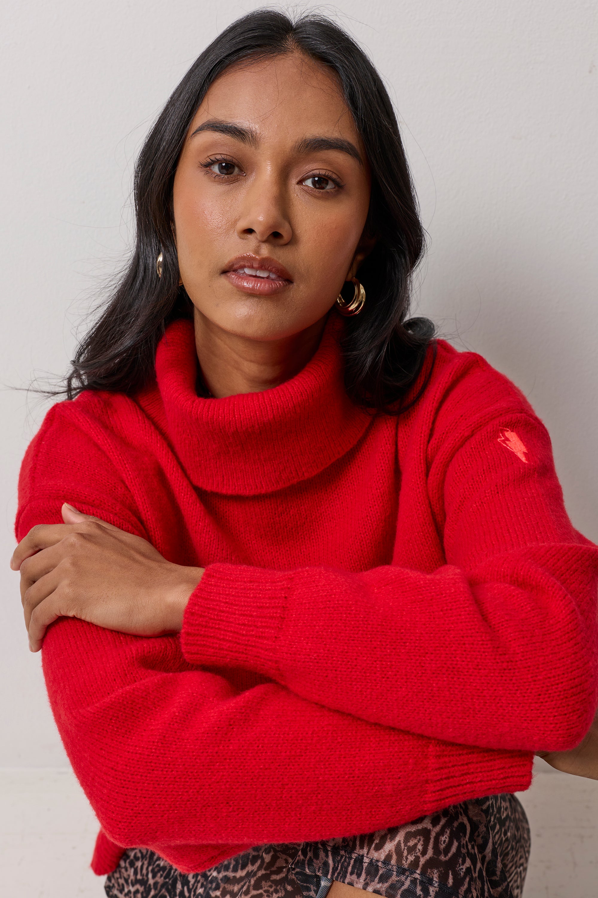 Scamp & Dude Red Roll Neck Knitted Jumper | Model wearing a ed roll neck knit jumper and a cheetah print skirt.