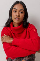 Scamp & Dude Red Roll Neck Knitted Jumper | Model wearing a ed roll neck knit jumper and a cheetah print skirt.