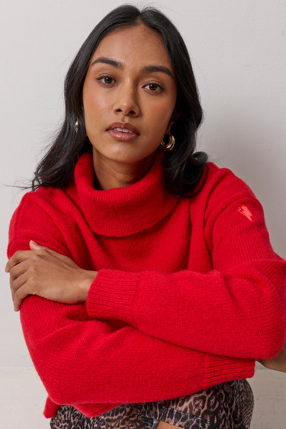 Scamp & Dude Red Roll Neck Knitted Jumper | Model wearing a ed roll neck knit jumper and a cheetah print skirt.