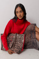 Scamp & Dude Neutral Milano Leopard Canvas Shopper Bag | Model wearing a red roll neck jumper with a neutral cheetah skirt and a matching shopper tote bag with a red embroidered bolt.