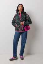 Scamp & Dude Green and Black Cloud Leopard Fleece Jacket | Model wearing a khaki cloud leopard print fleece with a pink bag and blue jeans.
