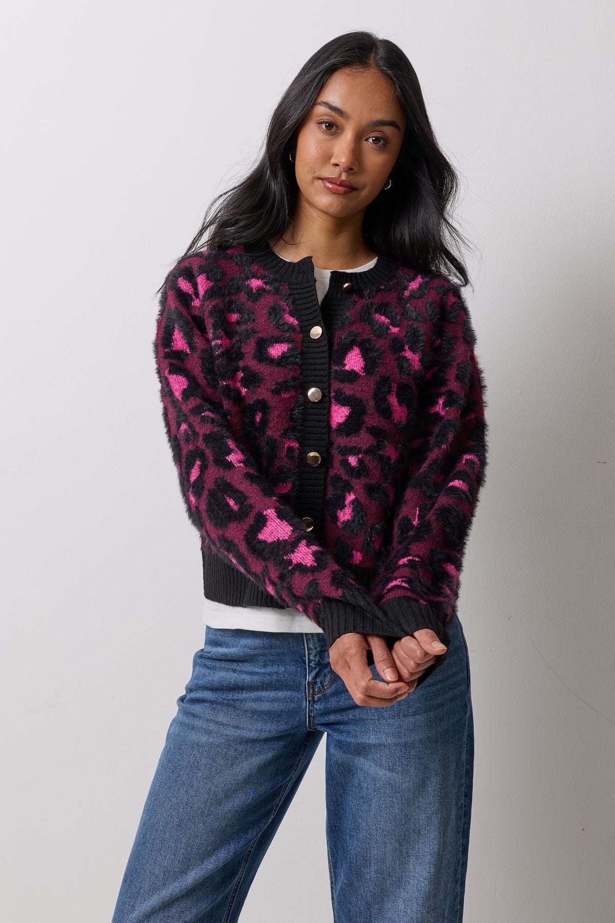 Scamp & Dude Berry Star Leopard Cardigan | Model wearing a berry coloured fluffy knit cardigan with a leopard and star print and gold buttons. Worn with blue jeans and a classic white t-shirt.