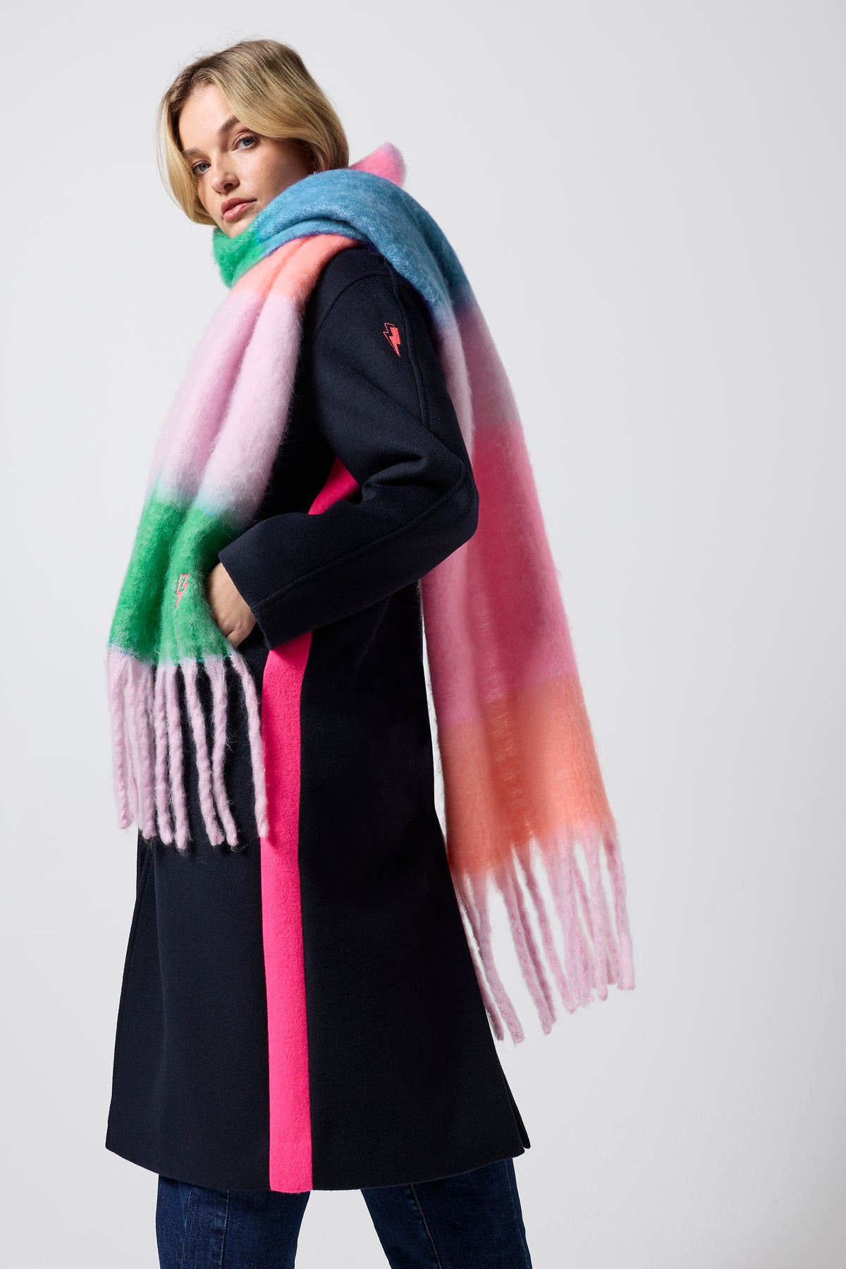 Scamp & Dude Multi Coloured Colourblock Fringe Scarf | Model wearing a navy coat with multicoloured fringe scarf.