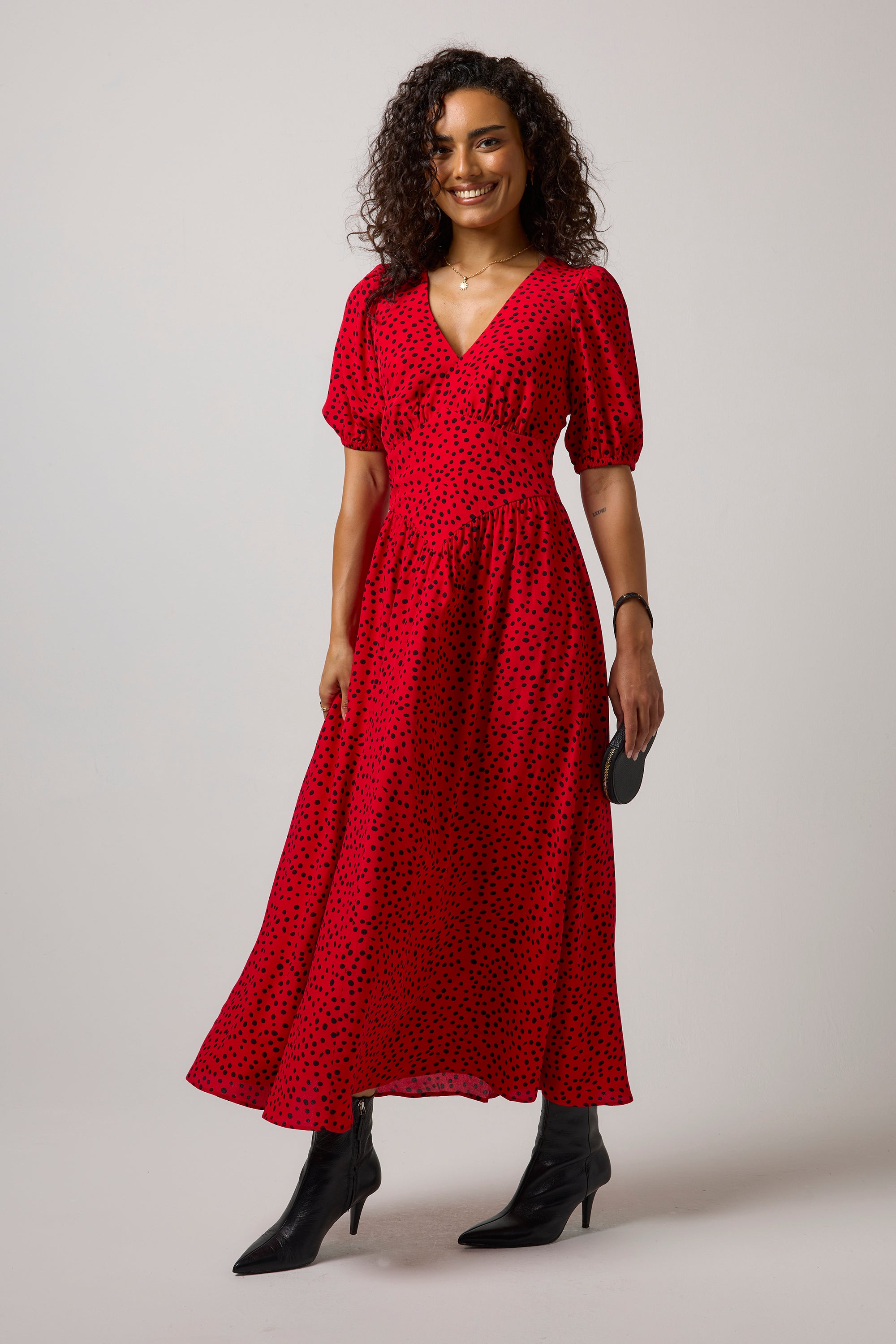 Scamp & Dude Red with Black Cheetah Spot Drop Waist Midi Dress | Model wearing a red animal print midi  with a pair of black boots.