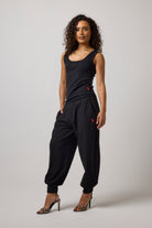 Scamp & Dude Black Barrel Joggers | Model wearing a black sleeveless vest top and matching black jogger pants and leopard heels.