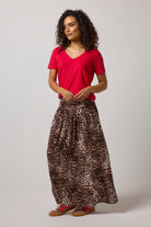 Scamp & Dude Neutral with Black Cheetah Drop Waist Midi Skirt| Model wearing a cheetah drop waist midi skirt paired with a red v-neck t-shirt.