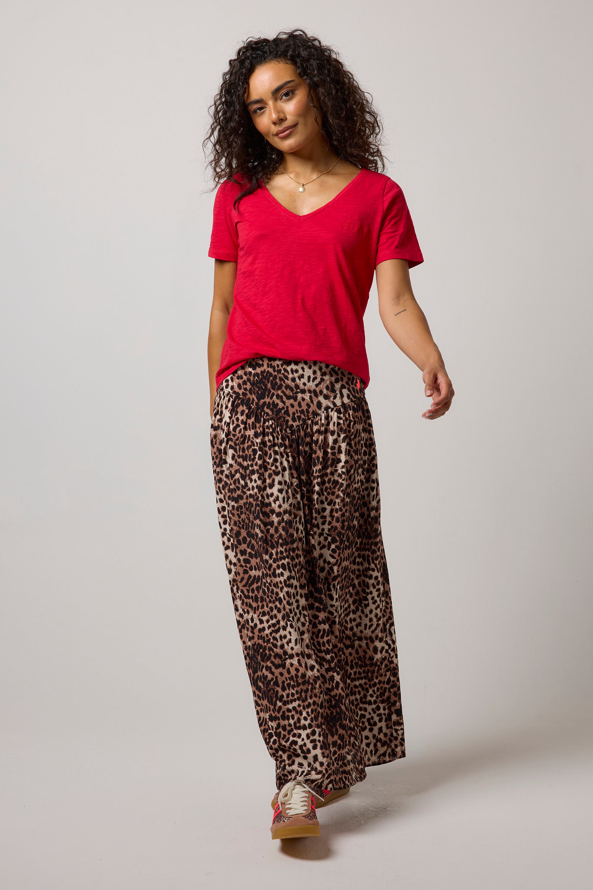 Scamp & Dude Neutral with Black Cheetah Drop Waist Midi Skirt| Model wearing a cheetah drop waist midi skirt paired with a red v-neck t-shirt.