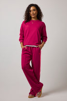 Scamp & Dude Burgundy Slouchy Stripe Detail Sweatshirt | Model wearing a burgundy sweatshirt with matching wide leg jersey trousers.
