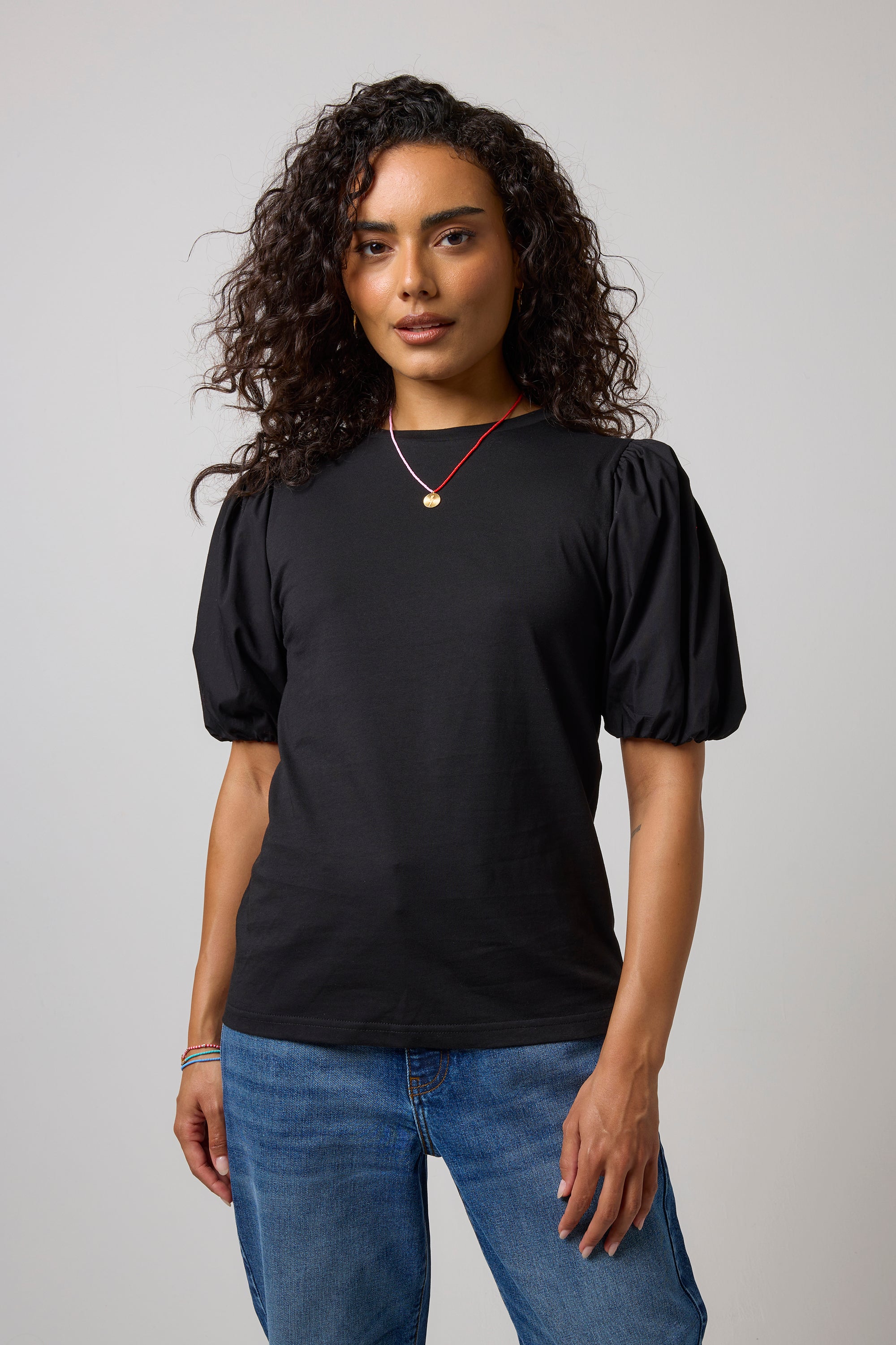 Scamp & Dude Black Puff Sleeve T-Shirt | Model wearing a black puff sleeve t-shirt with a pair of blue jeans.