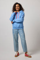 Scamp & Dude Blue Washed Ultimate Hoodie | Model wearing a light blue hoodie with red drawstrings, paired with light-wash jeans and neutral cheetah trainers.