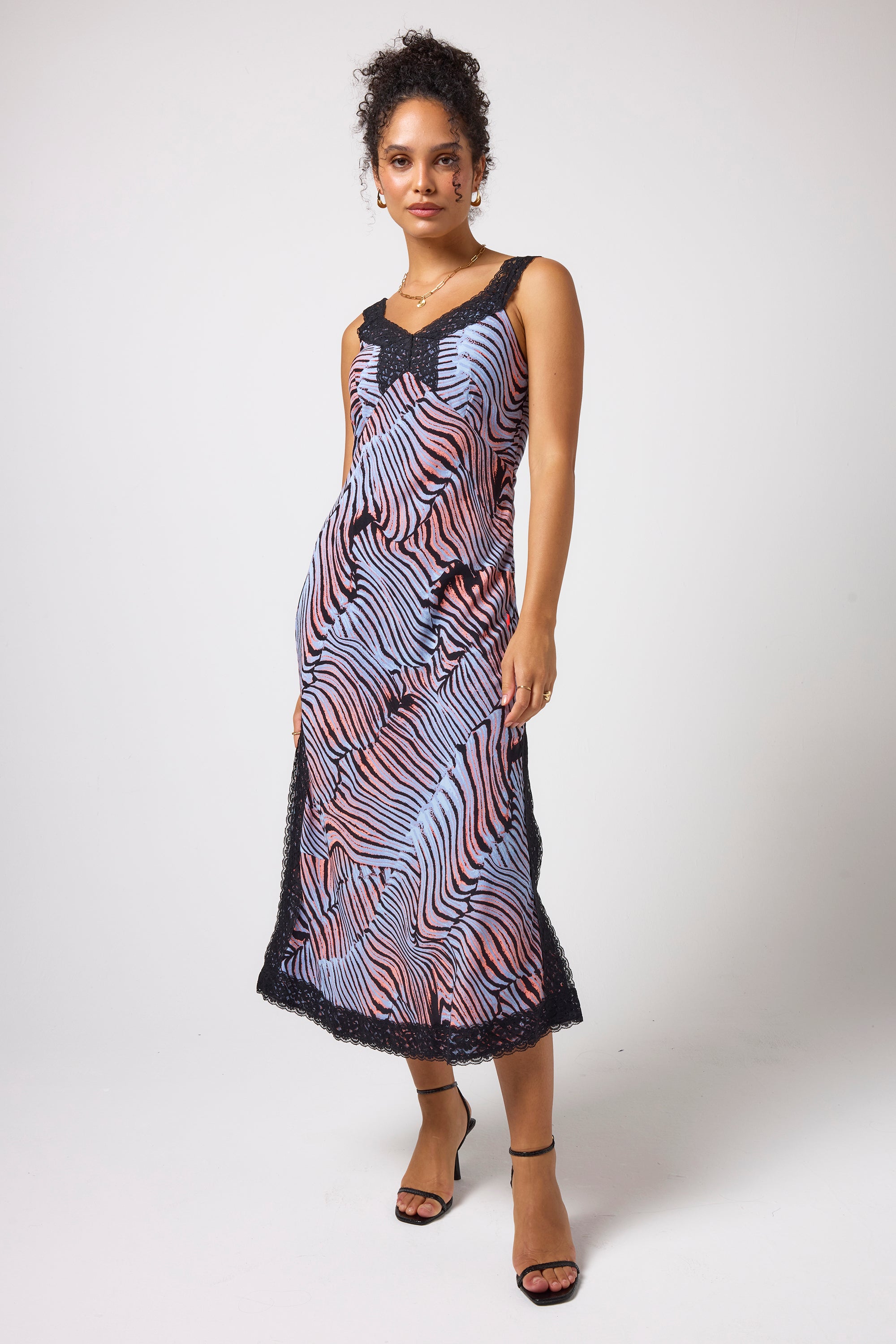 Scamp & Dude Blue with Coral and Black Tiger Moth Lace Detail Midi Slip Dress | Model wearing a sleeveless midi dress with a coral, blue, and black tigermoth pattern and black lace trim at the neckline and hem.