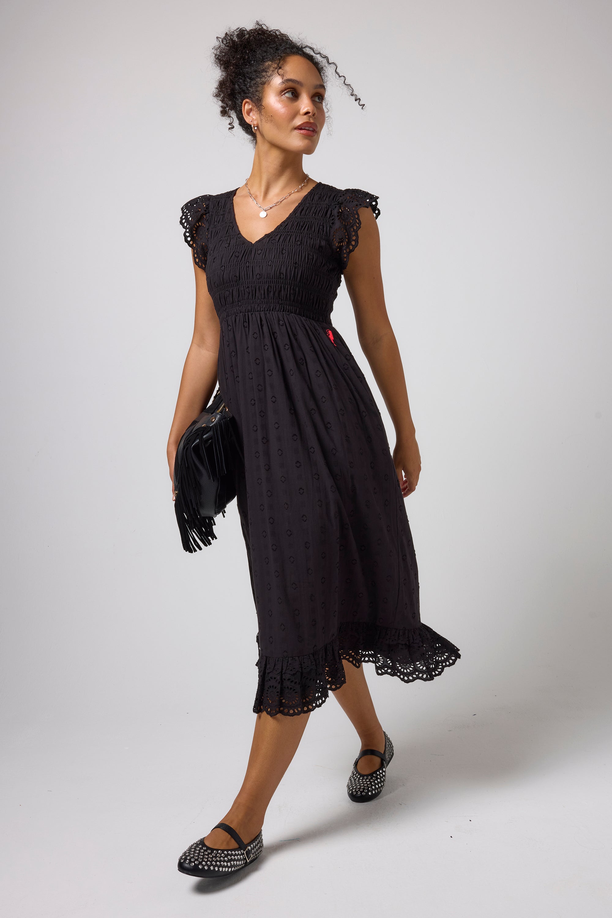Scamp & Dude Black Broderie Shirred Midi Dress | Model wearing a black midi dress with broderie sleeves and a smocked bodice.