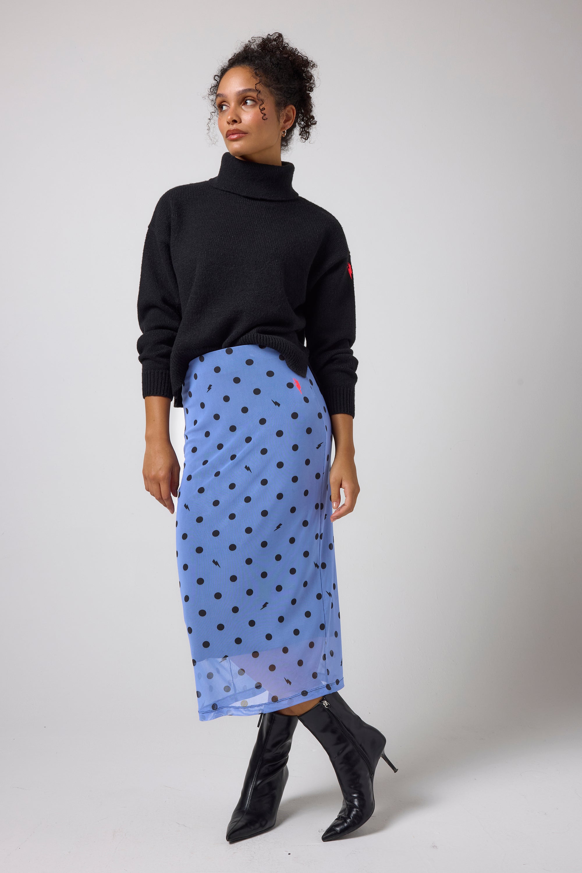 Scamp & Dude Blue Polka Dot Bolt Mesh Skirt | Model wears a blue polka dot mesh skirt with a black turtleneck jumper.