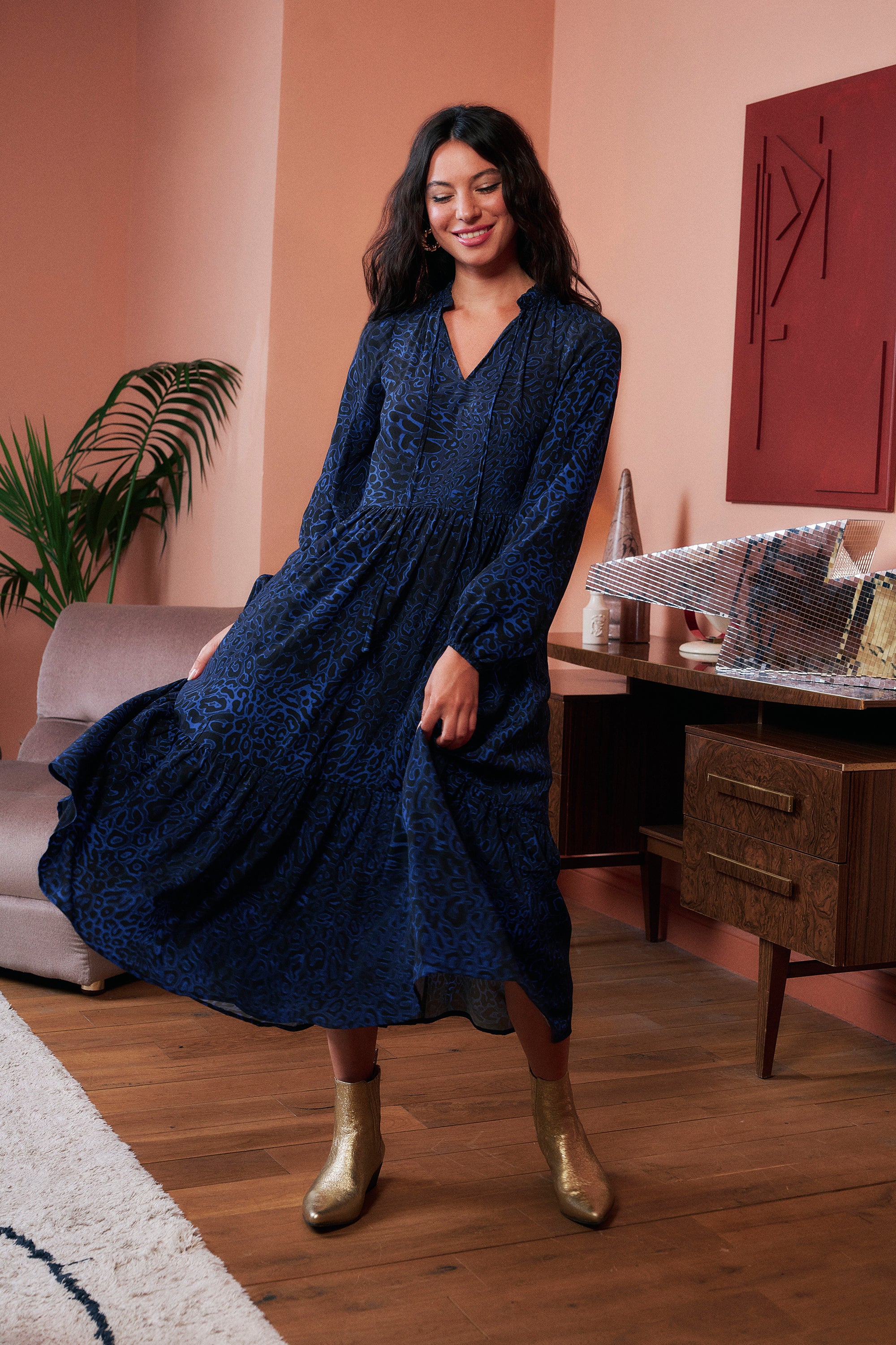 Scamp and Dude Navy Leopard Ray Blouson Sleeve Tie Front Midi Dress | Model wearing a long sleeve navy leopard ray print dress with tie front detail and gold boots.