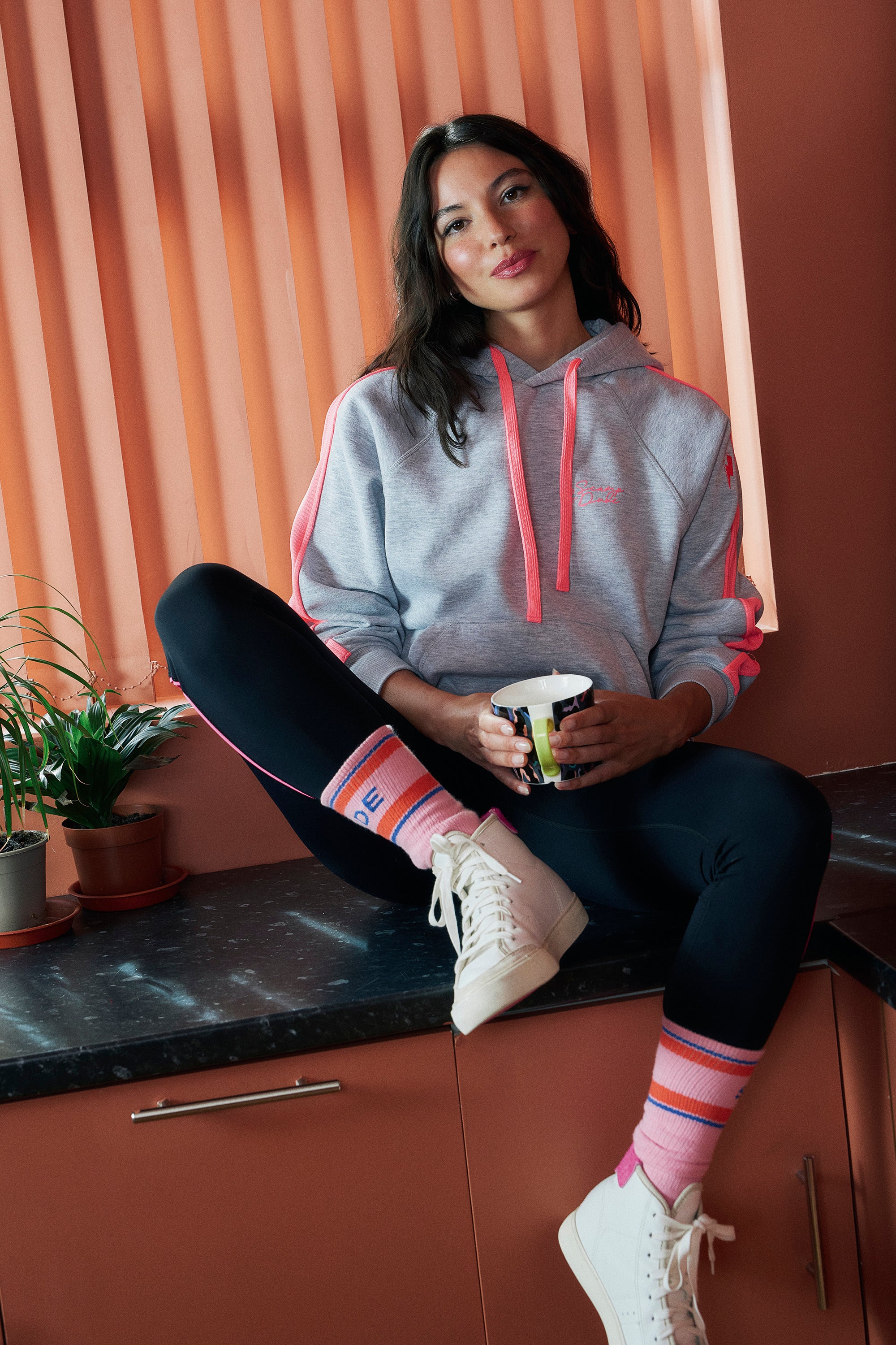 Scamp and Dude Light Grey Marl with Pink Colourblock Relaxed Hoodie | Model wearing a pair of black leggings and a grey and pink colourblock hoodie.