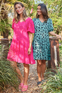 Two women wearing puff sleeve short dresses in different prints and colourways