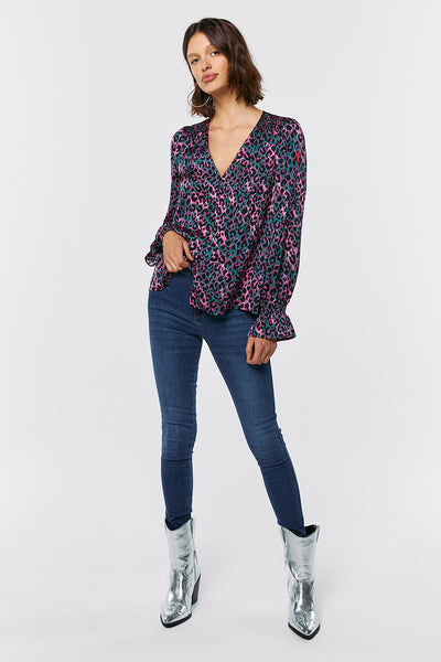 Scamp and Dude Khaki with Pink and Black Small Shadow Leopard Flute Sleeve Blouse | Model wearing pink and black leopard print blouse with blue jeans and silver boots