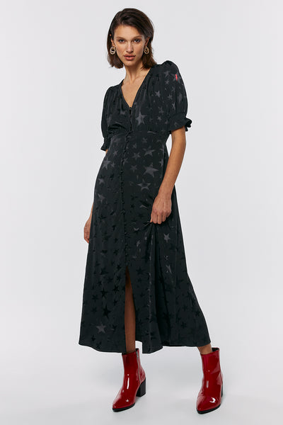 Scamp and Dude Black Jacquard Star Button Through Midi Dress | Model wearing a long black dress with black star print and heeled red boots