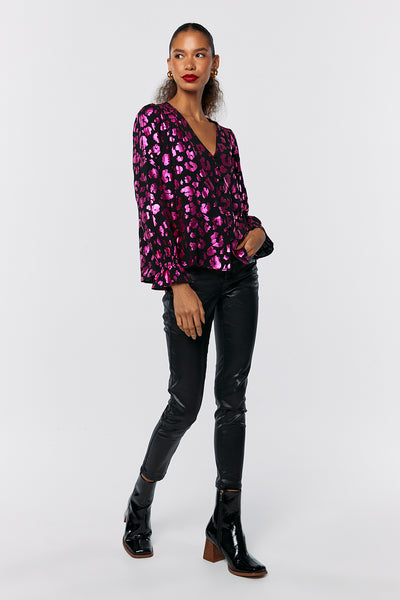 Scamp and Dude Black with Pink Foil Leopard Flute Sleeve Blouse | Model wearing pink metallic blouse with black leather trousers and black heeled boots