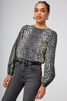 Scamp and Dude Khaki with Black Wild Leopard Blouson Sleeve Top | Model wearing jeans paired with a long sleeve khaki top featuring wild leopard print and bow detail at the back.