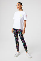 Scamp and Dude Navy Long Sleeve Jumper | Model wearing a white t-shirt with dark khaki leggings that feature rainbow leopard print. Worn with white trainers.