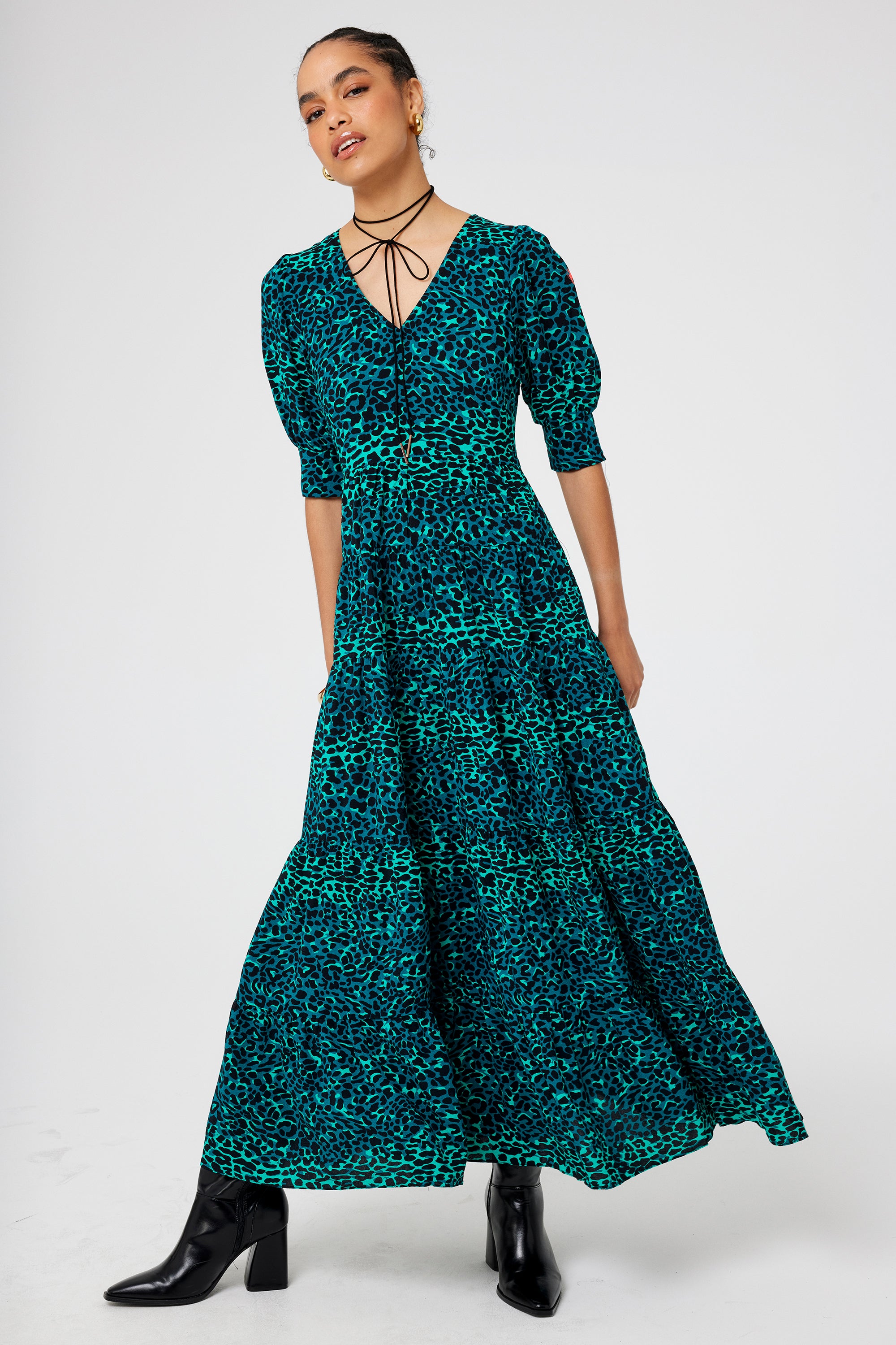 Scamp and Dude Green with Black Wild Leopard Maxi Dress | Model wearing a green leopard print v neck maxi dress with a tiered skirt.