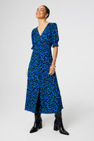 Scamp and Dude Blue with Green and Black Shadow Leopard Flute Sleeve Midi Tea Dress | Model wearing short sleeve midi tea dress in blue with green and black shadow leopard print paired with black boots.